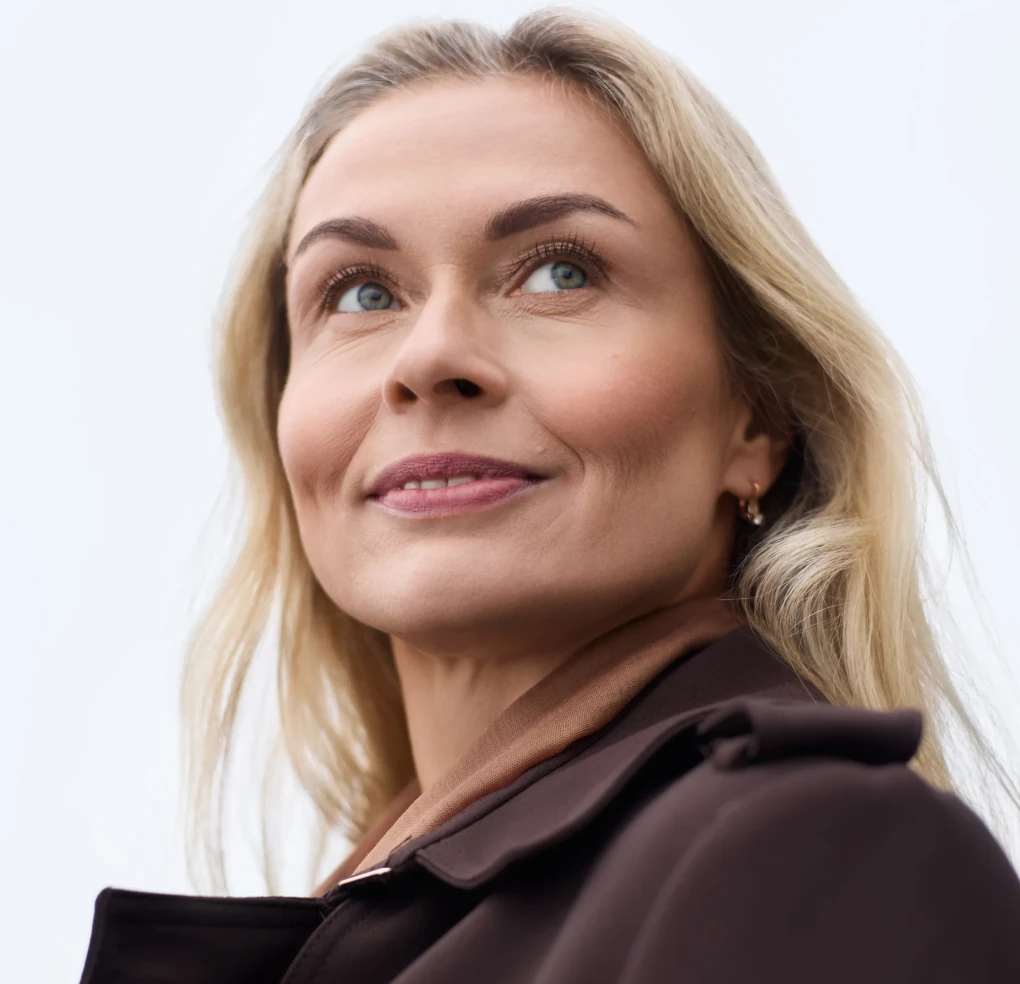 жінка 40 плюс дивиться вверх і посміхається